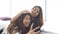 Slow motion - Beautiful young asian women LGBT lesbian happy couple sitting on bed hug and using phone taking selfie together.