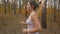Slow motion of beautiful young woman jogging in forest and taking short break