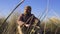 Slow Motion Beauty Shot of Serious Bearded man in Yellow Hat sitting in the High Grass. Spring of Autumn Weather in