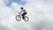 Slow motion bicycle jumper jumps high with bike sky background