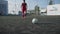 Slow motion bottom view young nimble soccer player runs and kicks ball by foot on large modern stadium