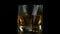 Slow Motion of Bubbles Forming in Whiskey in Glass with Ice in Dark Background