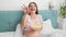 SLow motion of cheerful pregnant woman holding bowl of popcorn and throwing it in camera. Pregnant woman having fun and