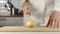 SLOW MOTION: Chef Chopping A Head Of Onion On Wooden Board While Cooking