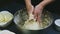 Slow motion chef by hands kneads soft yeast dough in big deep metal bowl
