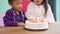 Slow motion - Children celebrate birthday`s party in classroom, Multi-ethnic young girls happy make a wish blow out candles on