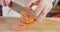 Slow motion close up of a chef knife slicing a tomato