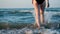SLOW MOTION, CLOSE UP: Female or girl feet step on yellow sand from seashells, go into the sea. The girl plunges into