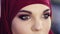 Slow motion close up footage of a girl wearing hijab opening her eyes with perfect colorful smokey make up on them