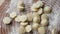 Slow motion. Close-up of homemade Russian fresh dumplings crumbling on the table. Freshly molded dumplings are poured