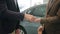 Slow motion close-up of men shaking hands in car showroom taking key fob