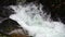 SLOW MOTION, CLOSE UP: Powerful raging whitewater waterfall falling forcefully over a rocky edge. Crystal clear glacier
