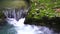 SLOW MOTION, CLOSE UP: Powerful raging whitewater waterfall falling forcefully over a rocky edge. Crystal clear glacier