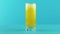 Slow motion close-up shot of fruit fizzy orange soda cold beverage drink pooring into glass blue background in studio
