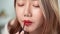 Slow-motion close-up video, pretty Asian women are using paintbrush, apply lipstick to the mouth