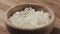Slow motion closeup cottage cheese falling into wood bowl