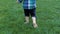 Slow motion closeup footage of adorable toddler boy feet running on fresh green grass at park