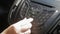 Slow motion closeup footage of drivers hand asjusting music volume on car dashboard