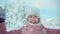 Slow motion Closeup portrait of cheerful smiling woman in pink parka throws up snow in snowy winter park in frozzy sunny