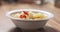 Slow motion closeup pouring cauliflower soup into bowl on wood table