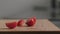 Slow motion closeup sliced cherry tomato fall on oak board