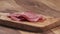 Slow motion closeup thin salami slices falling on cutting board