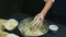 Slow motion closeup woman cleans hands from leftovers of dough above metal bowl