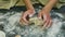 Slow motion closeup woman hands slowly knead small piece of yellow yeast dough