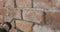 Slow motion closeup of worker filling seam between bricks with mortar from sealant gun