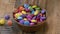 Slow motion, Colorful candies in a wooden bowl case isolated on wood background