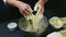 Slow motion of confectioner by hands kneads soft yeast dough in deep metal bowl