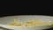 SLOW MOTION: Cooked farfalle fall into white empty plate