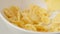 SLOW MOTION: Corn flakes fall on white dish close up
