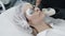 Slow motion cosmetologist makes girl procedure for moisturizing skin of face with special device