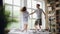 Slow motion of cute couple dancing on bed, jumping and laughing together having fun on weekend morning in nice light