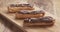 Slow motion of decorating eclairs with hazelnuts on wood board