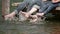 Slow motion detail of family feet playing in water while relaxing on wooden pontoon