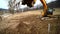 Slow motion of a digger digging a pit and throwing dirt. Close-up of a excavator bucket that throws out the earth. Shot