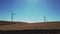 Slow motion driving by a windfarm on dry grass hills in California