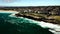 Slow-motion drone shot of Mahon pool and Maroubra beach with a foamy tide in Sydney, NSW, Australia