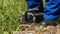 Slow motion electrician takes off climbing irons on green grass