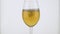 Slow motion. Falling of a stream of white wine in a wine glass.