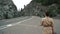 Slow motion of a female nomad strolling along the road. background for traveling