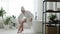 Slow motion of feminine student in bathrobe shaving legs in bathroom alone