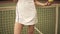 Slow motion footage from bottom upward of a young sportive female tennis player standing near the net