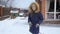 Slow motion footage of cheerful teenage girl throwing snow ball at house backyard