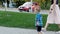 Slow motion footage of cute barefoot toddler boy walking with mother at park