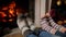 Slow motion footage of family in woolen knitted socks lying at burning fireplace on Christmas eve