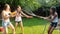 Slow motion footage of happy cheerful family having fun in garden with water guns and garden hose. Splashing water on