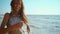 slow motion footage of happy joyful fitness girl in bikini running along sand sea beach